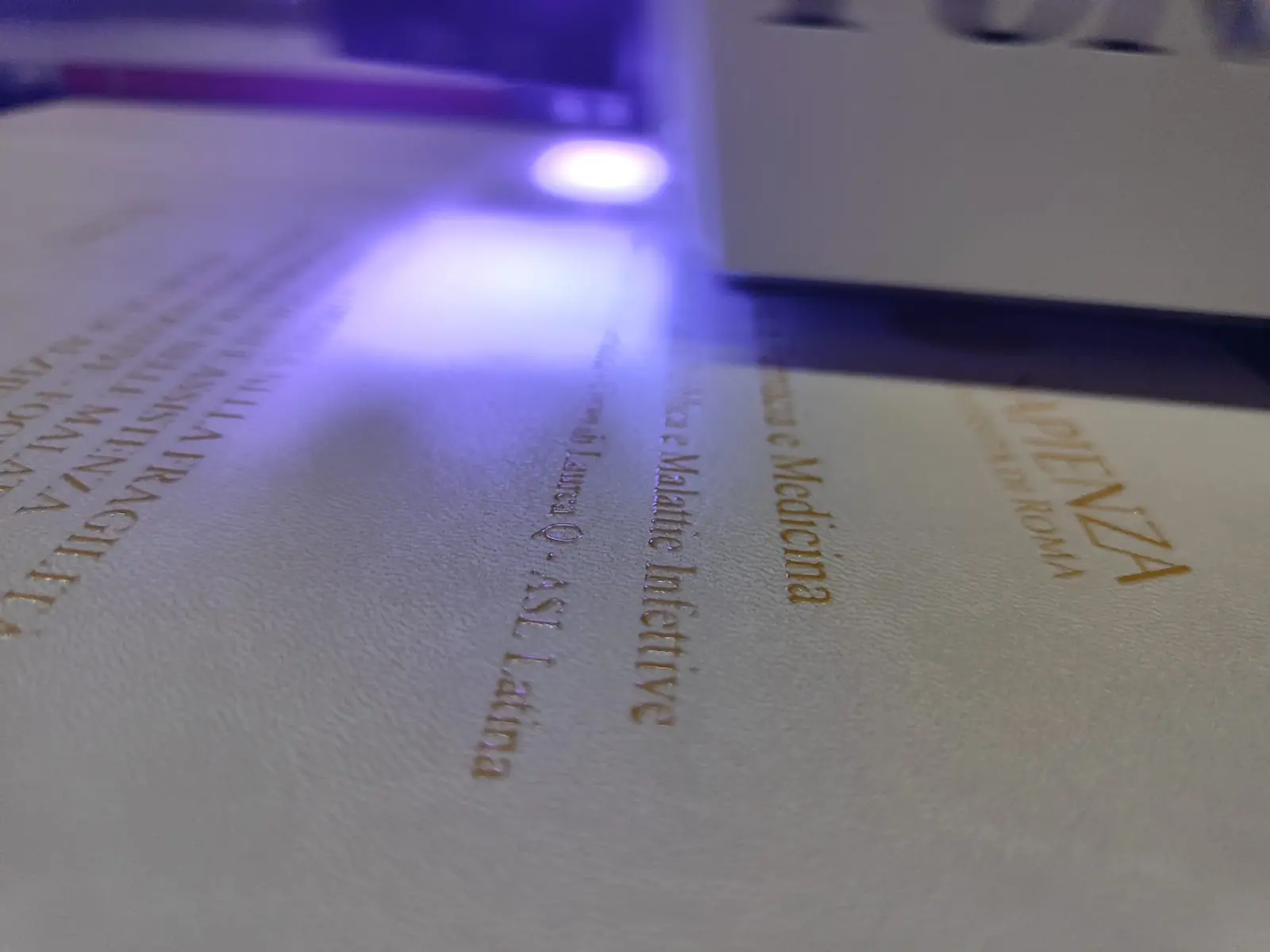 Copertina per tesi mentre viene personalizzata con stampa UV in rilievo